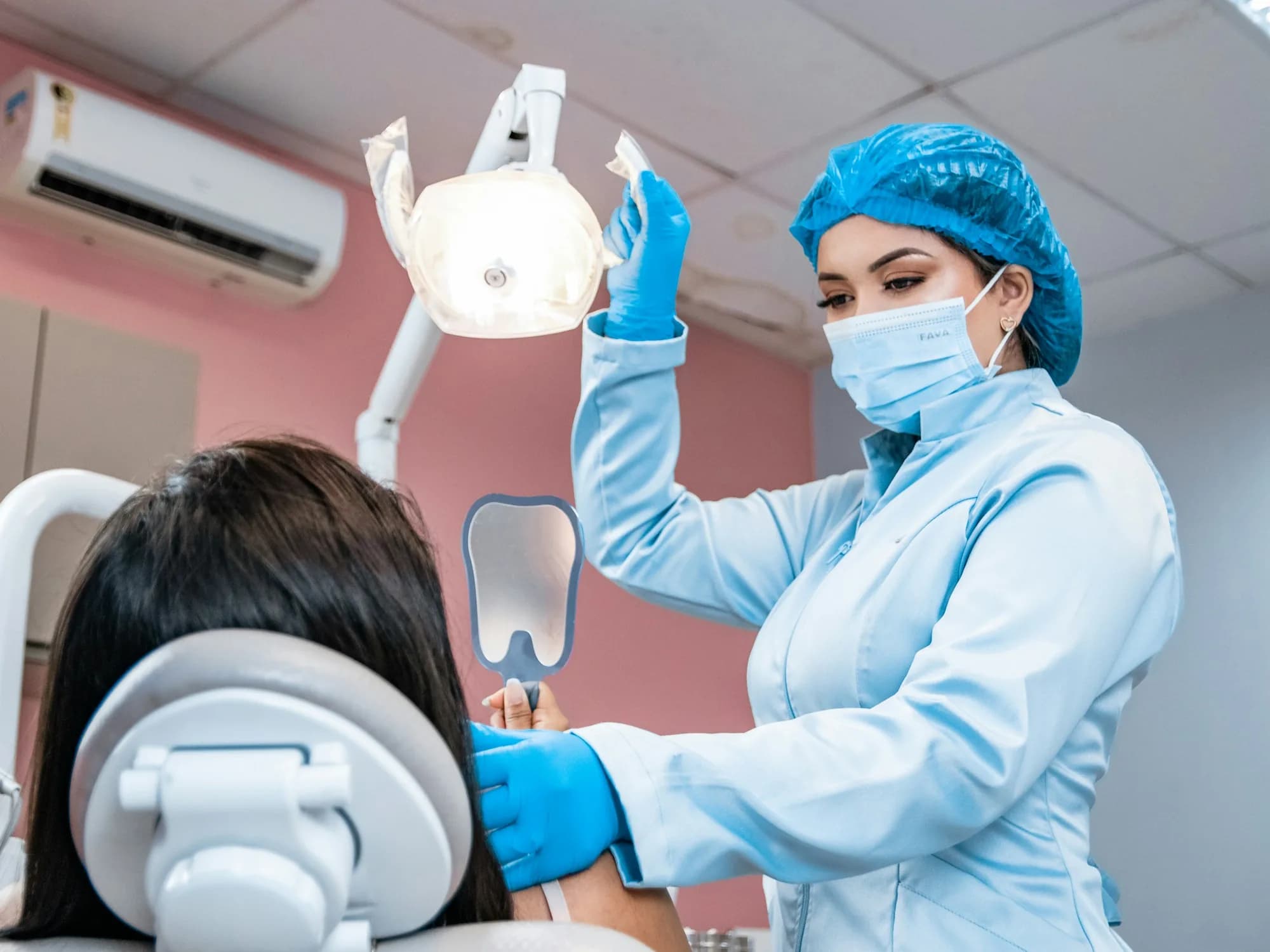 Zahnärztin neben einer Patientin auf dem Behandlungsstuhl